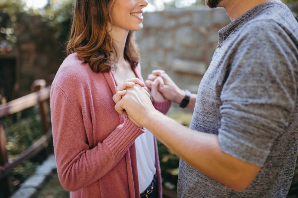 Interpersonal Intelligence: How to Decode Your Partner’s True Feelings A smiling couple holding hands outdoors representing interpersonal intelligence and connection.