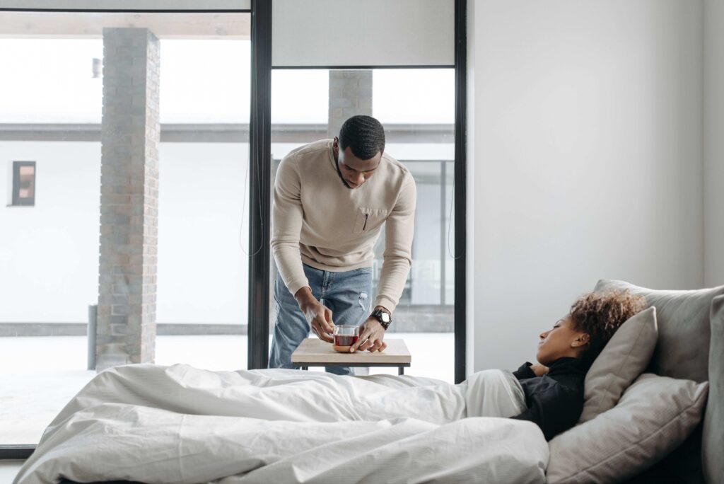 A caring partner bringing drink to bedside representing mature romantic partnership and support.