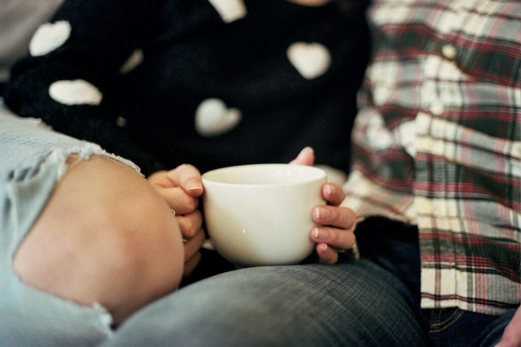 Is Love an Emotion? The Neurobiology of Attachment and Desire A person holding a coffee cup thoughtfully reflecting whether is love an emotion or a primal drive.
