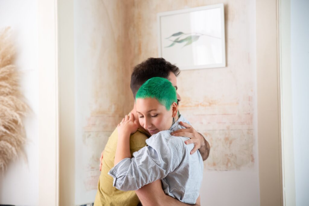 A couple embracing warmly indoors illustrating emotional reaction vs feeling in healthy love.