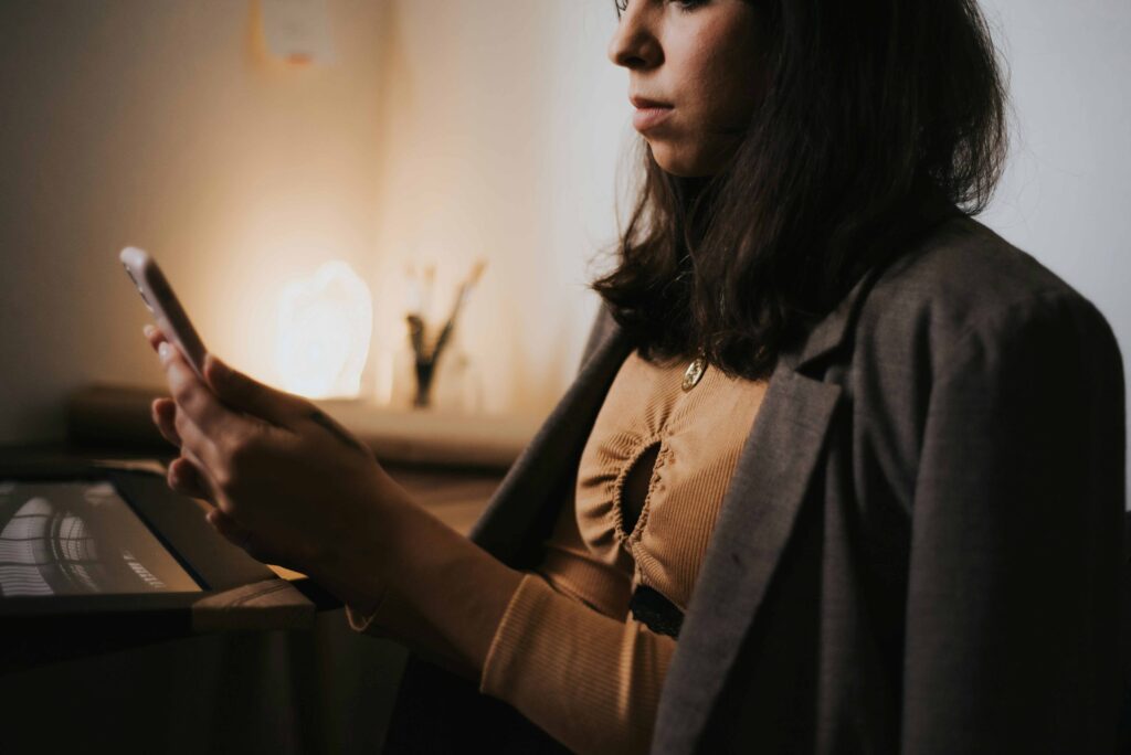 A woman checking her smartphone indoors questioning is love real beyond mere brain neurochemistry.