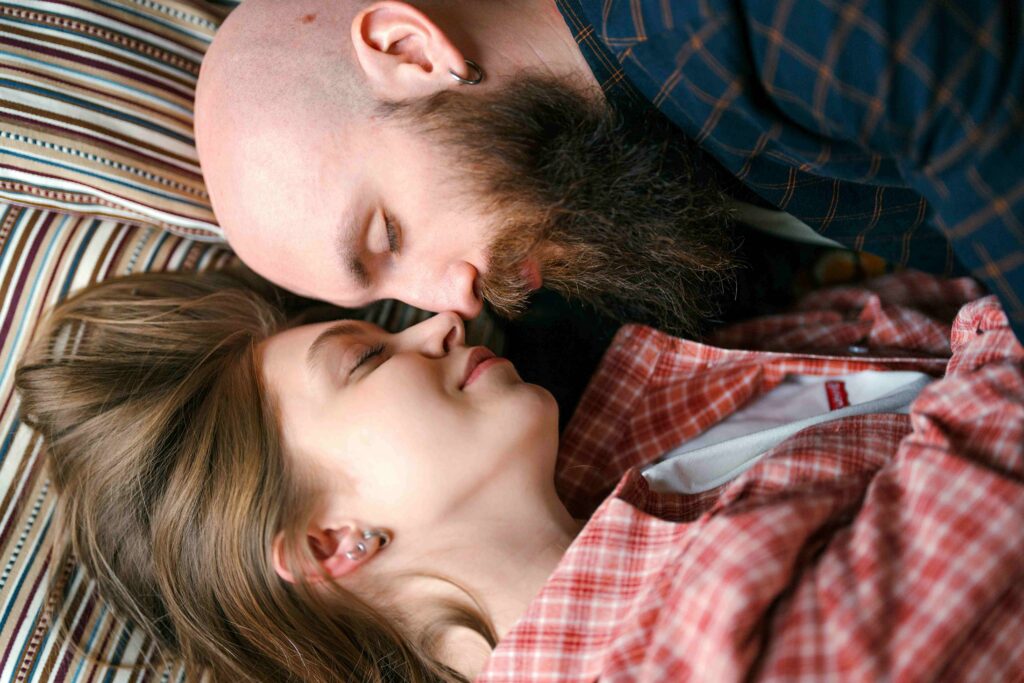 A loving couple resting heads together in bed representing avoidant attachment healing.