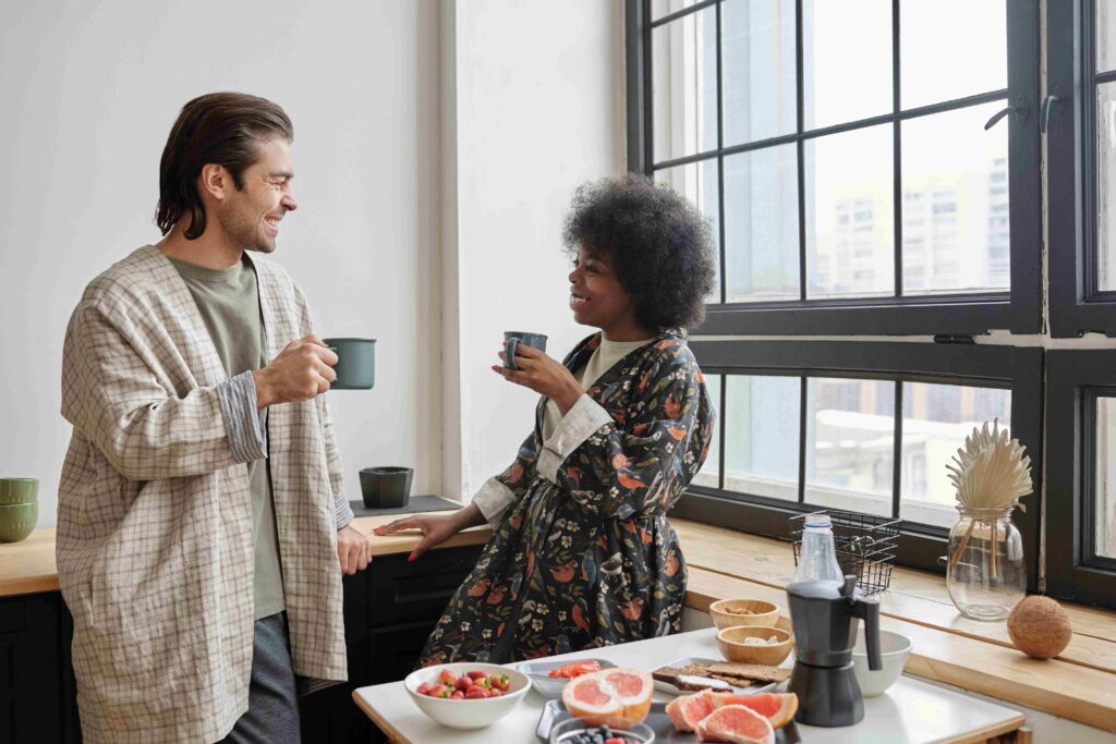 Linguistic Intelligence: How Your Words Make or Break a Marriage A smiling couple drinking morning coffee in the kitchen representing linguistic intelligence.