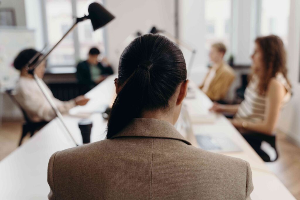 A businesswoman sitting at conference table holding a mysterious allure mindset at work.