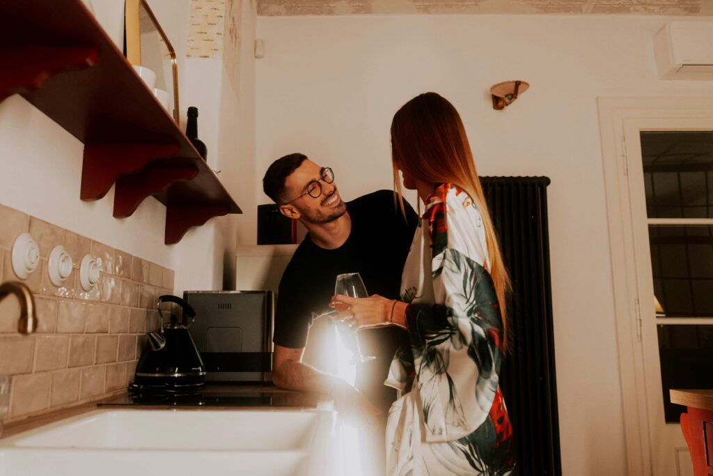A happy couple laughing in kitchen illustrating loving someone for who they are without judgment.