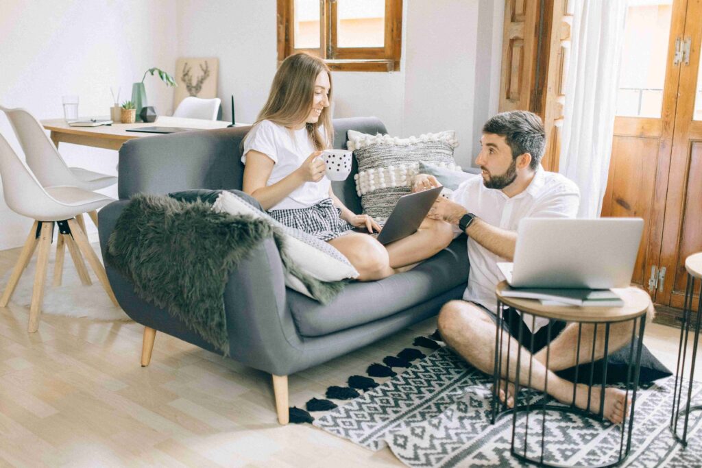A couple relaxing in living room with laptop showing genuine emotional compatibility and ease.