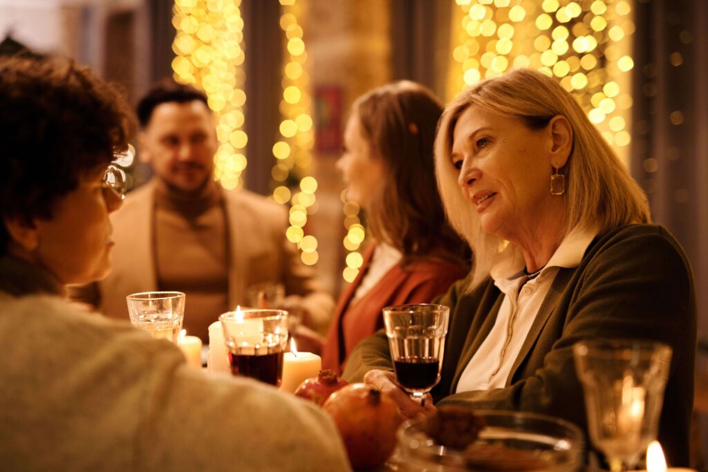 Family members having tense dinner conversation reflecting controlling in laws behavior.