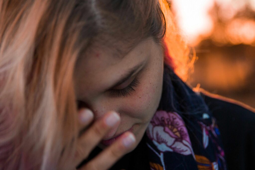 A woman crying and covering face illustrating relationship freeze response during conflict.