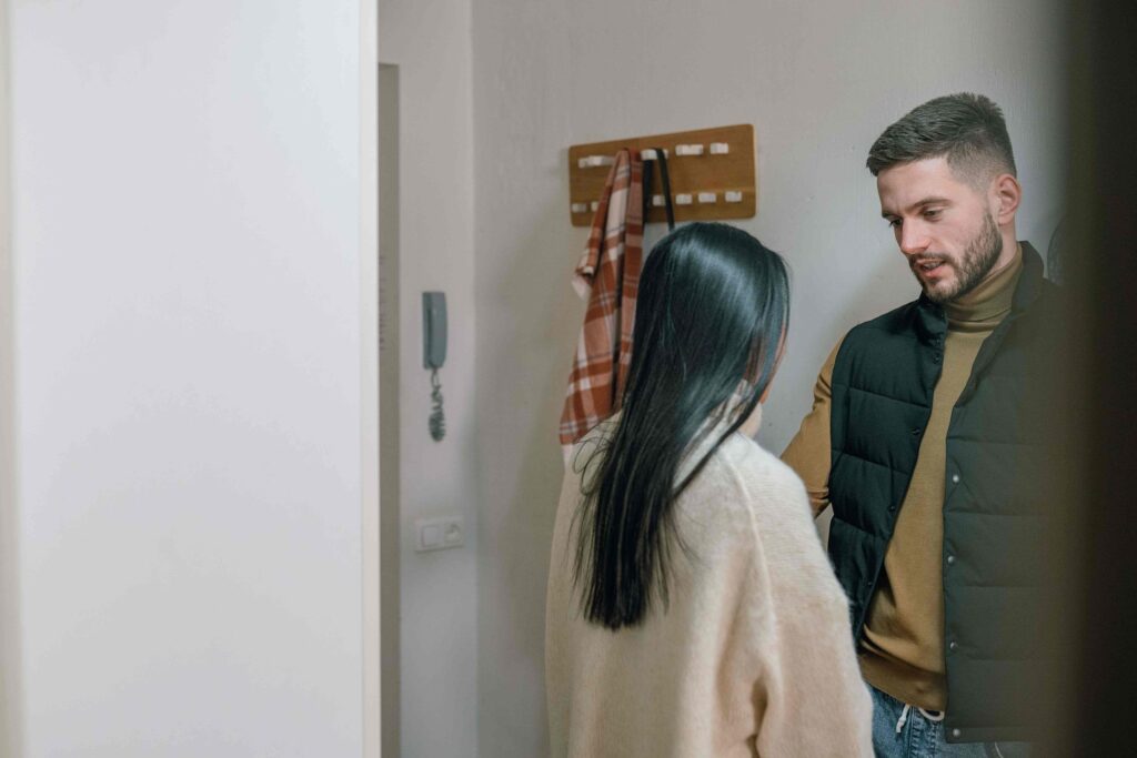 A man and woman standing in the hallway discussing internal emotional regulation.