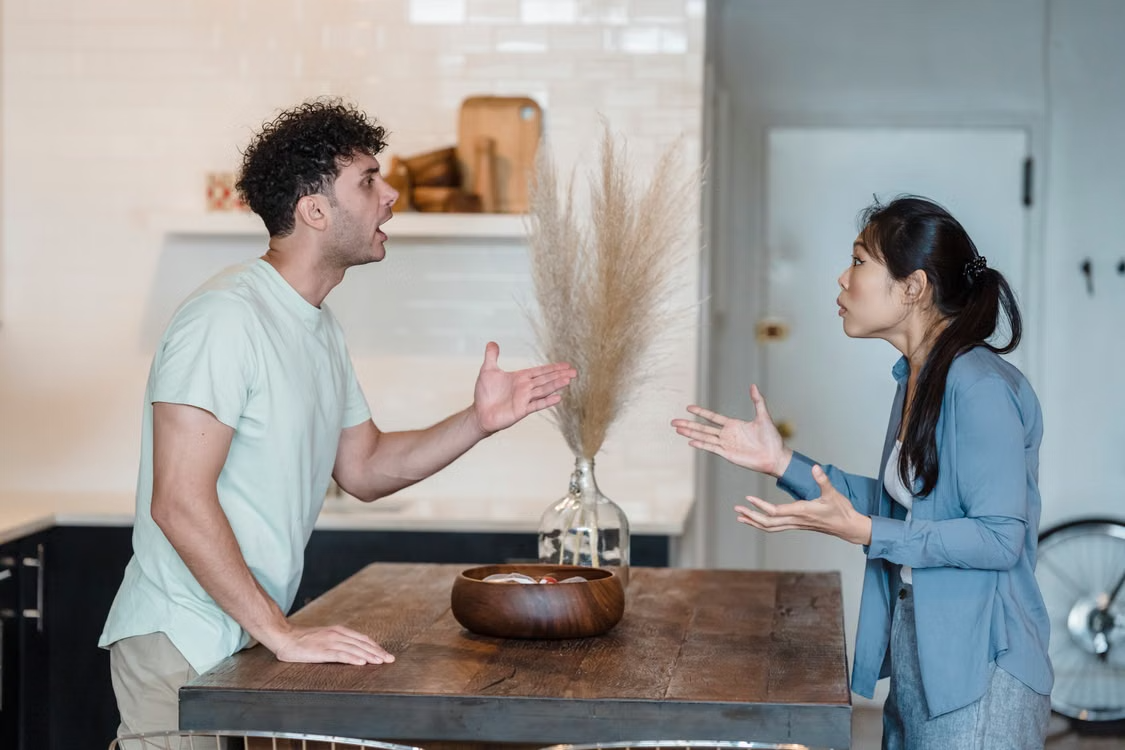 A couple arguing intensely in the kitchen demonstrating conflict and void marriage reasons.