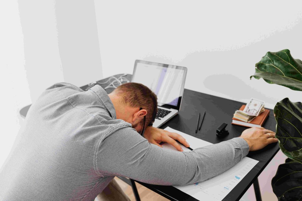An exhausted man sleeping at office desk illustrating psychological dream categories.
