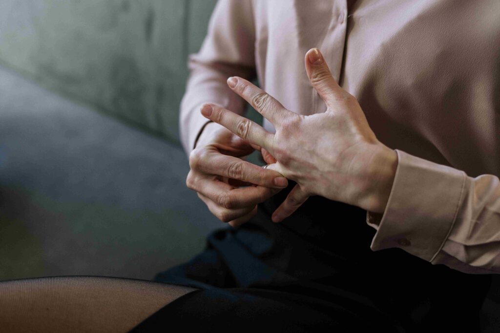 Close up of hands taking off a wedding ring showing emotional infidelity signs.