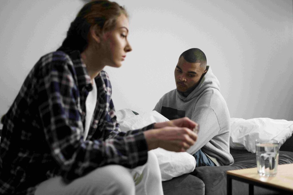 A couple having serious talk in bedroom while processing nighttime stress signals together.