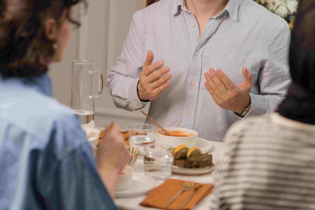 How to Make Friends as an Adult: 9 Rules for Meaningful Connections A group of friends dining and talking at dinner table exploring how to make friends as an adult.