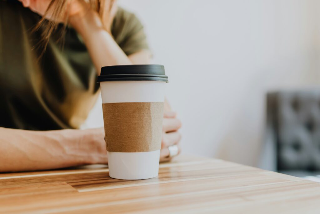 I Have No One to Talk To: How to Cope With Loneliness Right Now A lonely woman sitting at a table with coffee coping with feeling like i have no friends to talk to.