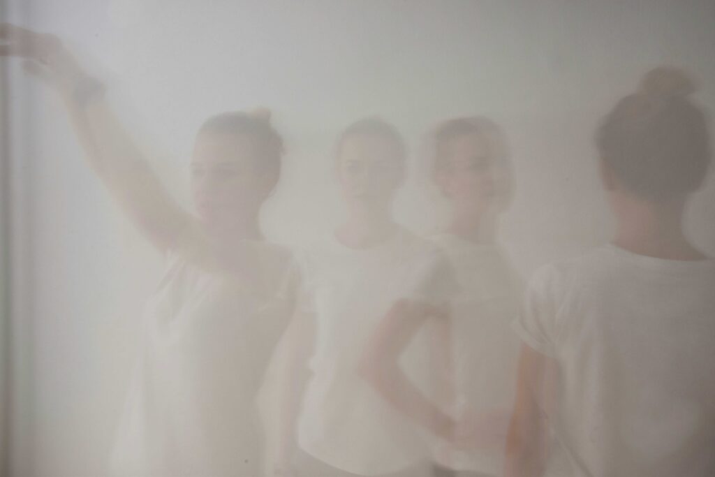 Misty figures standing behind glass reflecting subconscious dream symbols and memories.